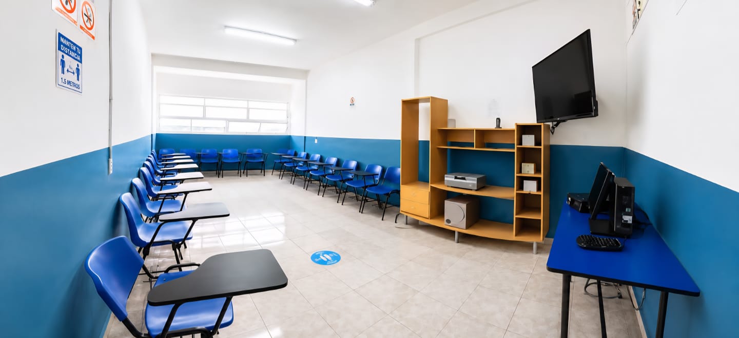 Aula equipada con pantalla y computadora